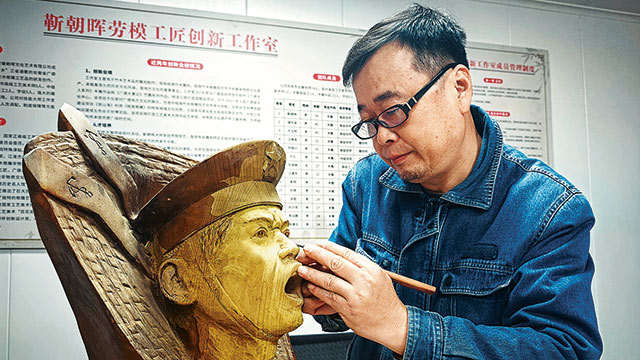 退役軍人靳朝暉用根雕技藝創作國防題材作品